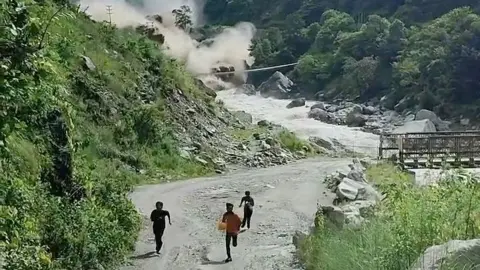 Men run from valley as water crashes down behind them 