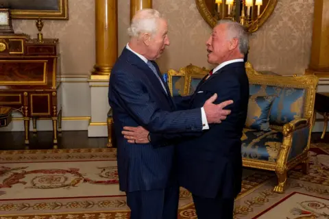 Jordan Pettitt/PA Media King Charles III greets Jordan's King Abdullah at Buckingham Palace. The two men are pictured face to face and they look pleased to see each other.