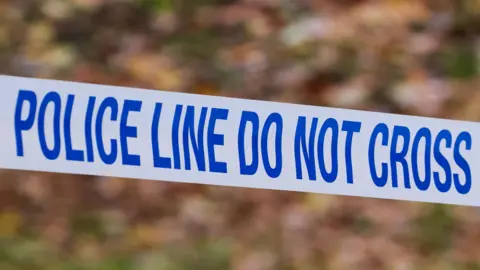 Blue and white police tape bearing the words: "Police line do not cross"