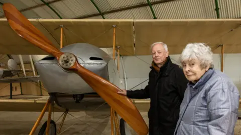 Dave Davies/SMGWA Eleanor is inside the aerodrome next to a WW1 plane and is standing next to her nephew Nick Kitto.