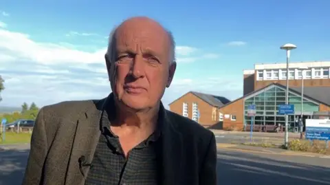 Kevin Earley, wearing a tweed jacket and a shirt, outside Shotley Bridge Hospital.