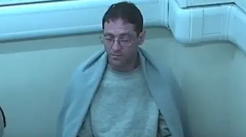 Robert Rhodes, pictured in a police interview in 2016, orchestrated a plot to kill Dawn Rhodes and claim he did so in self-defence