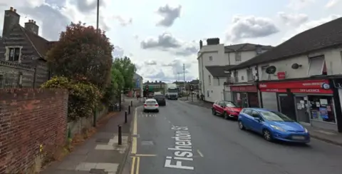 Google A view of Fisherton Street with shops and parked cars on a cloudy day