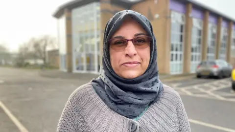 Parent Afifa Tufail stands in front of Alderbrook School