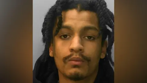 Sussex Police Yannan Reid in a police mugshot with a stern expression.