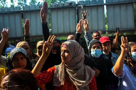 Reuters People flash three-finger salutes as they attend the funeral of U Khin Maung Latt in Yangon, 7 March