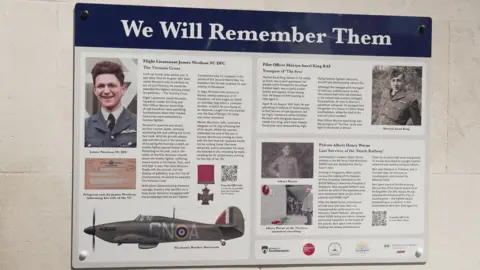 The special infographic memorial plaque that honours Wing Cdr James Nicolson VC, Pilot Officer Martyn Aurel King and Pte Bert Warne, displayed on a University of Southampton building. It contains images and written information.
