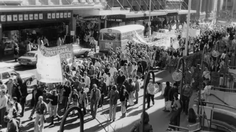 Australian Lesbian and Gay Archives Marchers walk down a street during the 1978 Mardi Gras and Gay Solidarity Group protests in Sydney