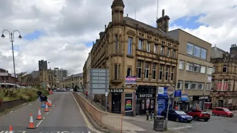 La Salsa lap dancing club on Silver Street in Halifax town centre, with street cones in the main road to the left and parked cars down Silver Street to the right