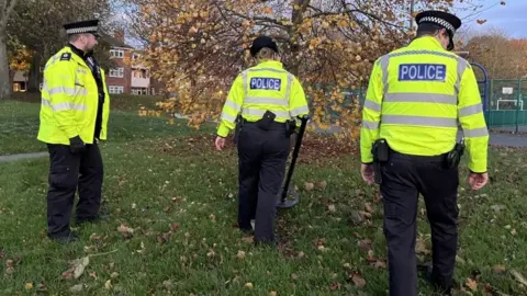 Andrew Turner/BBC Police team using a metal detector