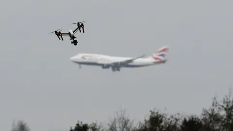 PA Media Drone flies in foreground as British Airways plane can be seen in the background