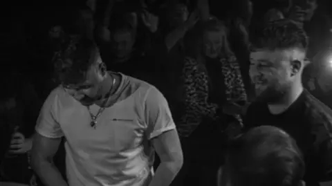 Two Connors/ hjwphotography Two young men in a music venue - the photo is black and white.