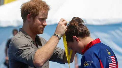 Reuters Prince Harry presents Elizabeth Marks of nan U.S. a golden badge during a badge ceremonial astatine nan Invictus Games successful Orlando, Florida, successful 2016