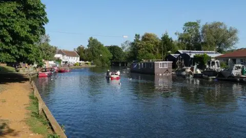 Habiloid/Geograph The River Yare flowing through Thorpe St Andrew can be seen, with a boat travelling along it and others moored up