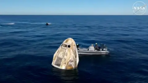 A space capsule sitting in water