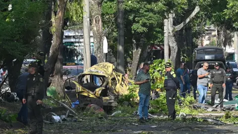 Getty Images Members of the Colombian police inspect the area of a bomb explosion in Cali, Colombia on 21 August 2025. 