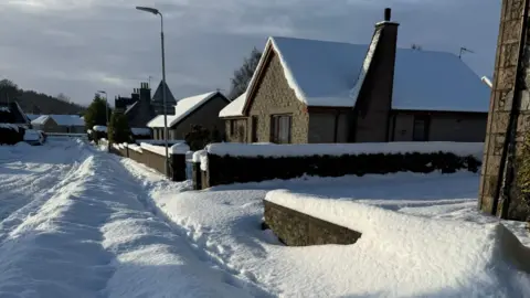 Deep snow surrounding a street of bungalows