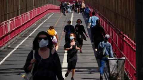 Getty Images People crossing the Williamsburg bridge in New York wearing face masks