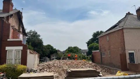 BBC Rubble of bricks in place of where three terraced houses once stood 
