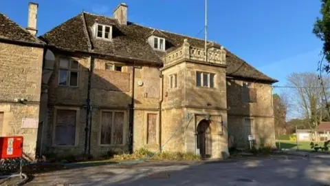 Wiltshire Council Picture of the outside of the listed Melksham House building. Windows can be see boarded up.