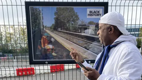 A man observes one of the photos on exhibit at Gloucester train station