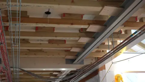 Jamie Niblock/BBC Wooden roof supports all over the ceiling at West Suffolk Hospital.