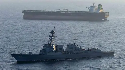 A US military ship is seen in the foreground in the Arabian Sea in April, while another ship is seen in the background.