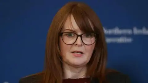 PA Dr Caoimhe Archibald wearing black glasses and black suit