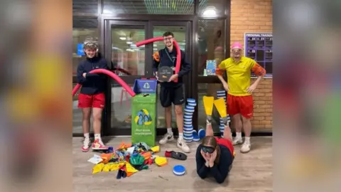 Wiltshire Council A group of people wearing swimming equipment like swimming caps, flippers and goggles. 