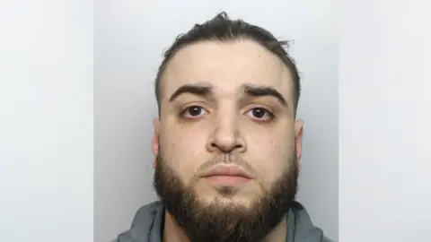 Thames Valley Police A mugshot of Hamze Almallah, who has dark hair tied back and a brown beard. He is emotionless as he stares ahead 