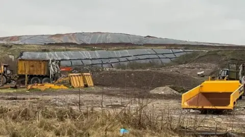 A landfill site in the middle of a grassy area