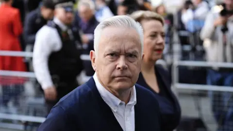 PA Media Edwards wears a white shirt and a navy cardigan 