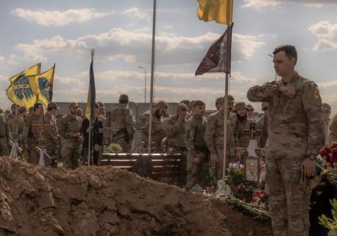 Azov Brigade fighters pay their respect at a grave 