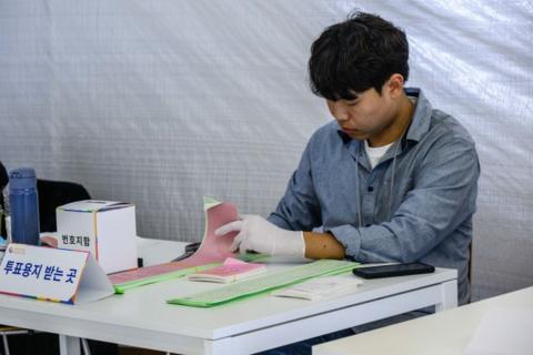 An official sorts through ballots at a polling station in Seoul on April 10, 2024, 
