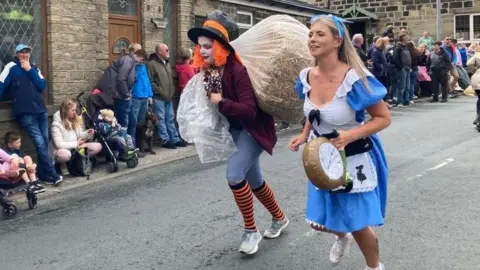 Competitors carrying a bale