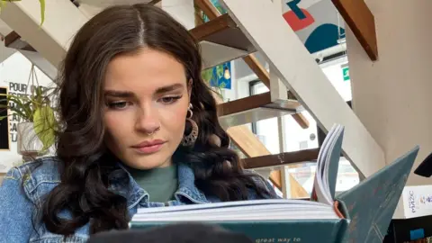 Amanda White/BBC Woman reading book at club in Hull