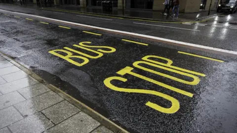 Getty Images Generic image of bus stop writing on the road