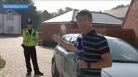 Channel One Russian TV reporter pointing at a British policeman