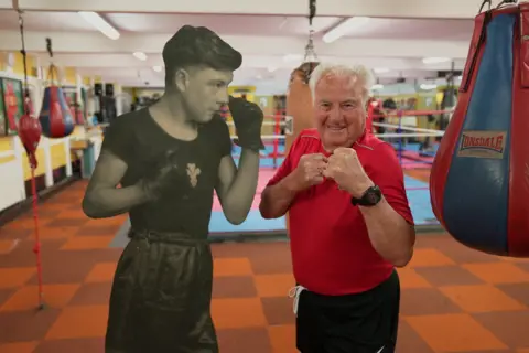 Keith poses with a cardboard cut-out made from a photo of him winning a Welsh title in 1949