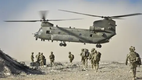 PA British soldiers approach a Chinook helicopter in the Nahr-e Saraj district, Helmand Province, Afghanistan