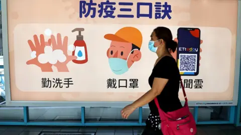 Reuters Woman wearing a face mask in Taipei