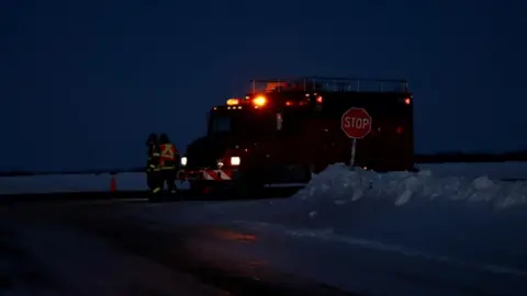 CBC Still from video footage, darkened scene with snow and emergency vehicle visible