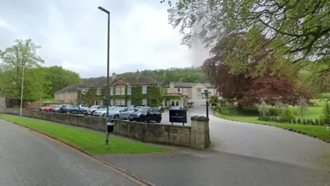 Google Image showing a large hotel surrounded by trees 