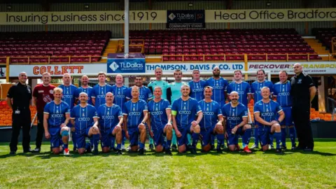 University of Bradford Firefighters lined up wearing Bradford City kits at the University of Bradford stadium