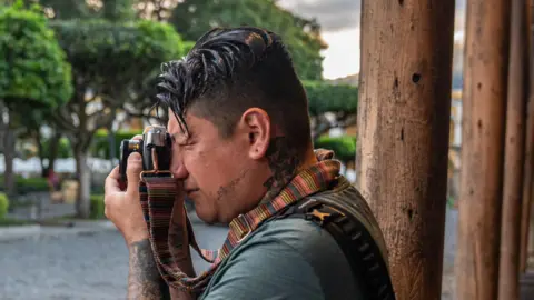 Fritz Pinnow Steven López looks through the viewfinder of his analog camera in Antigua, Guatemala.