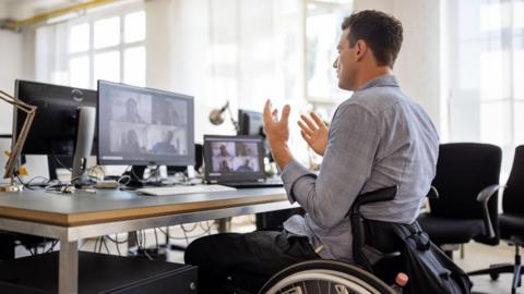 A stock image of a wheelchair bound office worker