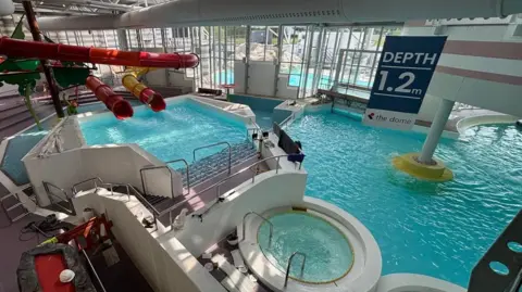 City of Doncaster Council A leisure centre swimming pool area with slides, a jacuzzi and large pool