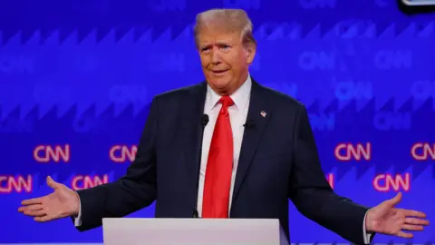 Donald Trump onstage with his arms splayed out