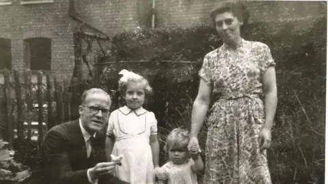 Family handout Marjorie with her daughters and husband in 1953 in a garden