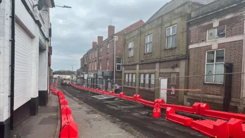 High street lined with fencing and bollards on either side
